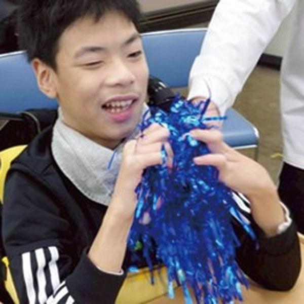 ポンポンを手に笑顔の男の子