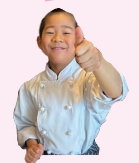 シェフの衣装で親指を立てる男の子
